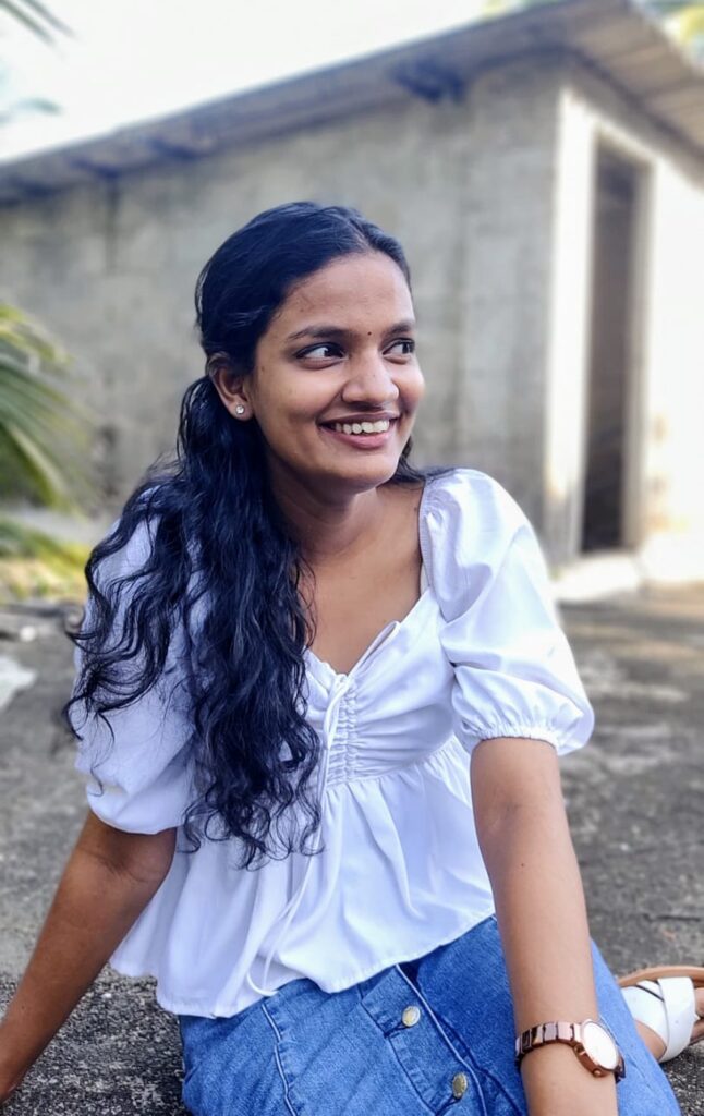 A woman in a white shirt and blue jeans sits on the ground, representing the best digital marketing consultant in Kerala